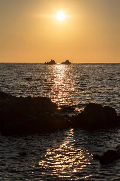 Beau coucher de soleil sur le bord de mer rocheux — Photo