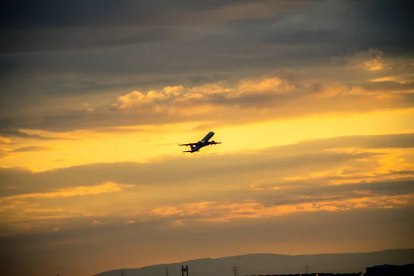Sziluettjét repülőgép naplementekor — Stock Fotó