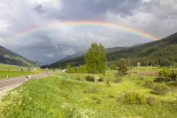 Arco iris sobre carretera y montañas — Foto de Stock