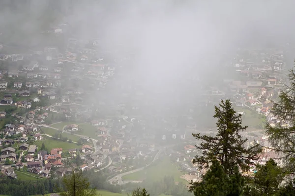 Alpské vesnice v oblacích mlhy — Stock fotografie