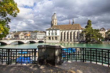 Limmat Nehri ve ünlü Grossmuenster Kilisesi, Zürih, İsviçre için görüntüleyin
