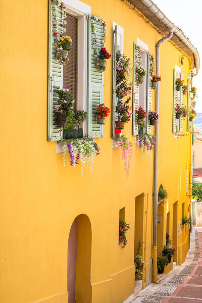 Traditional yellow house with white shutters in Menton on the French Riviera