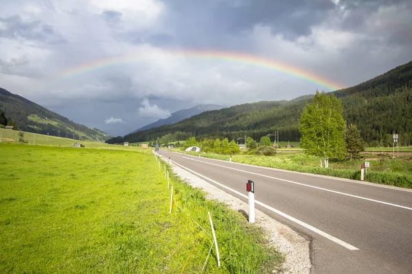 Arcobaleno sopra strada e montagne — Foto Stock