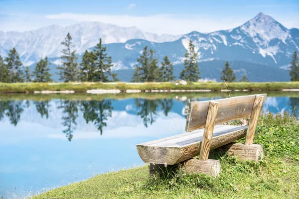 Mountain lake landscape view with bench in foreground — ストック写真
