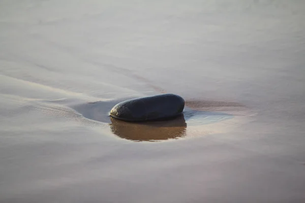 Pedras na areia molhada — Fotografia de Stock