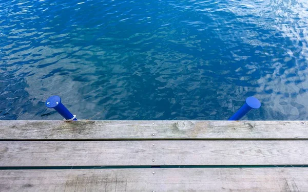Houten wharf en blauw water — Stockfoto