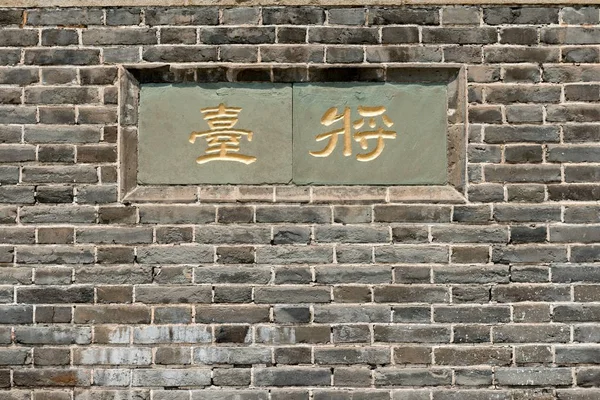 Escritura china en pared de ladrillo — Foto de Stock