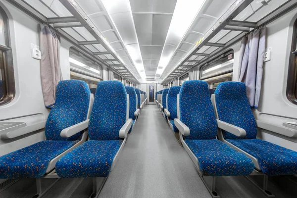 Leerer Zuginnenraum mit blauen Stühlen — Stockfoto