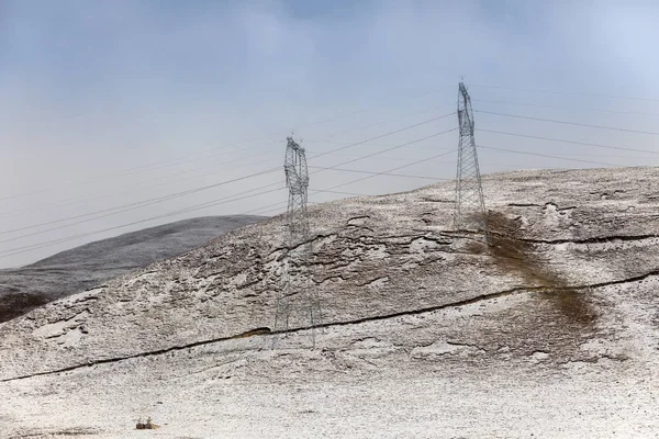 Снежные склоны с электрическим пилоном — стоковое фото