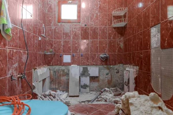 Damaged interior of old bathroom with red tiles — Stock Photo, Image