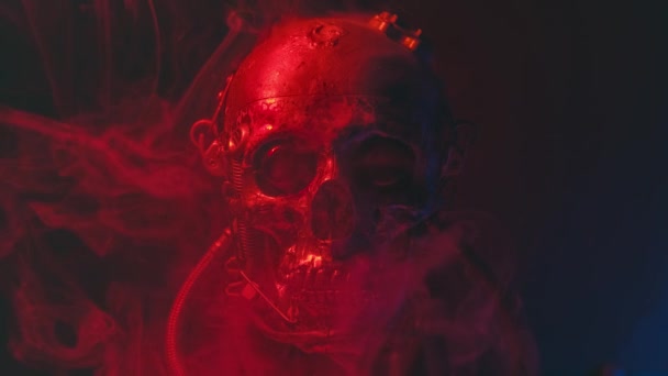 Robotic skull in red light with smoke — Stockvideo