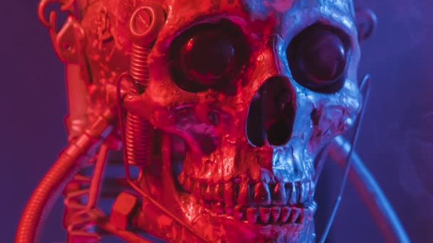 Robotic skull in red and blue light with smoke — Stockvideo