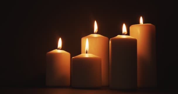 어두운 곳에 있는 커다란 두꺼운 촛불 막대기들 — 비디오