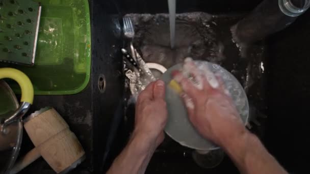 Washing dirty dishware in black sink — Stock Video