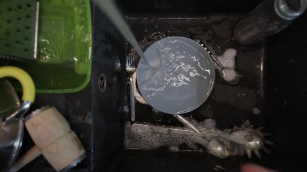 Tvätta smutsiga diskmaskiner i svart diskbänk — Stockvideo