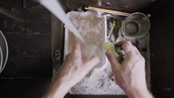 Мытье грязной посуды в черной раковине — стоковое видео
