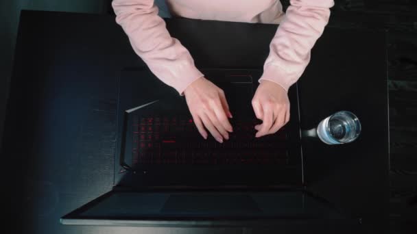 女性はテーブルでノートパソコンに座って水を飲み — ストック動画