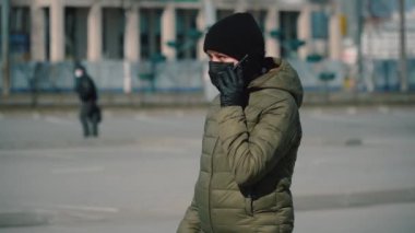 Maskeli hamile kız dışarıda telefon karantinasında.