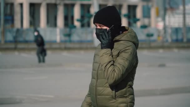 Zwanger meisje in een masker buiten door de telefoon quarantaine — Stockvideo