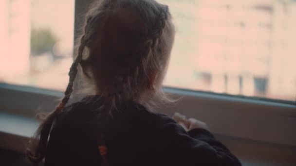 Ребенок смотрит в окно скучно каранин коронавируса обратно — стоковое видео