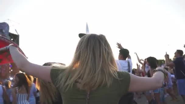 コンサートの女の子は群衆の後ろで手を挙げ — ストック動画