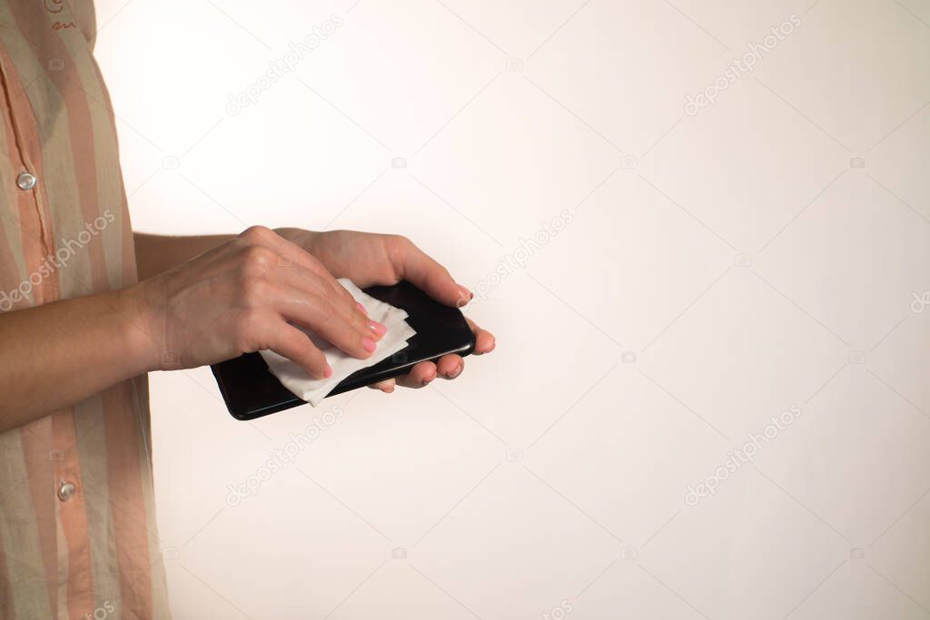 woman washes a phone with an antiseptic