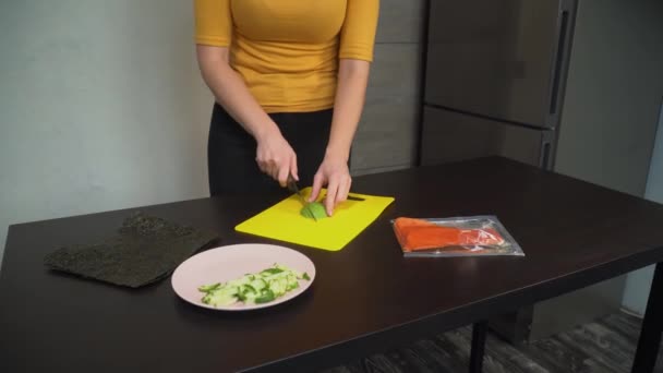 Mujer cocinar cortes de aguacate en la mesa — Vídeo de stock