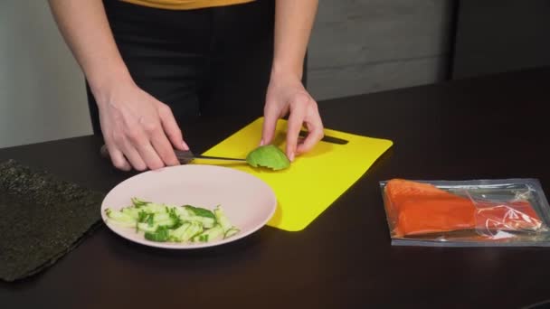 Женщина повар режет авокадо на столе — стоковое видео