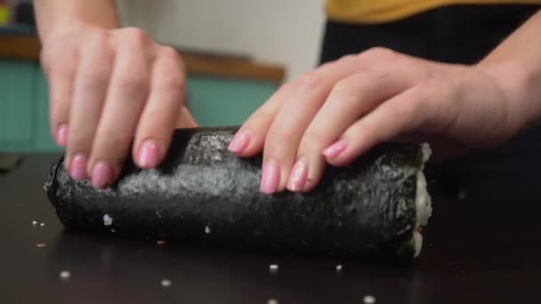 Женщина катит домашние суши на стол крупным планом — стоковое видео