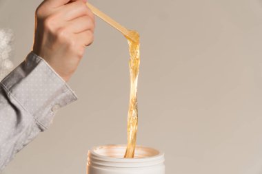 Güzellik uzmanı sallanan ışık arkaplanı için macun çiziyor