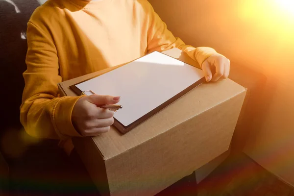 女孩拿着一个封闭的纸盒 用来在家里运送和包装不必要的东西 网上交货单 — 图库照片