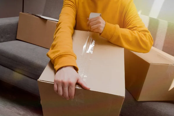 女性的手插入一个纸板箱特写在轻薄的背带上 搬运个人物品的包装 — 图库照片