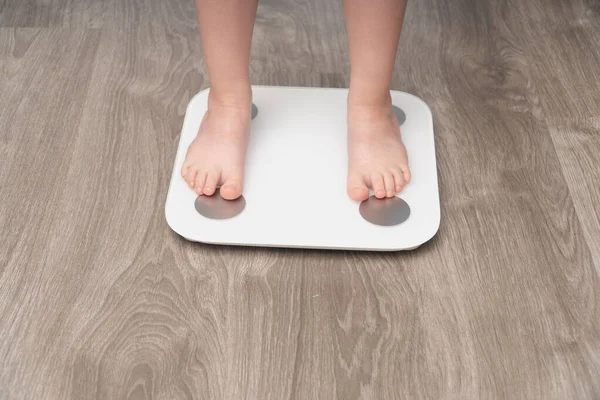 站在天平上的孩子的脚的特写 婴儿体重控制概念 — 图库照片