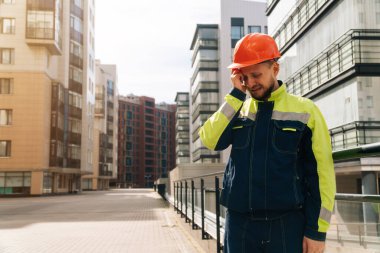 Miğferli adam yakın plan, şokta, başını tutuyor. İtfaiye kavramı. ev yandı.