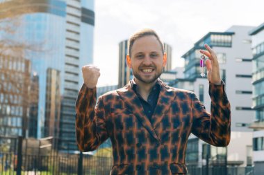 Neşeli emlakçı müstakbel alıcılara dairenin anahtarlarını gösteriyor. Emlak satma kavramı.