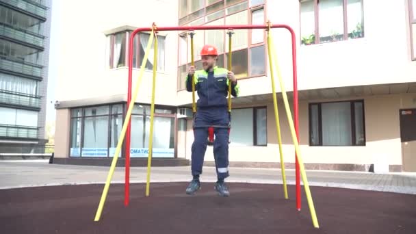 Ein Junger Gut Gelaunter Bauarbeiter Schaukelt Auf Einer Schaukel Einem — Stockvideo