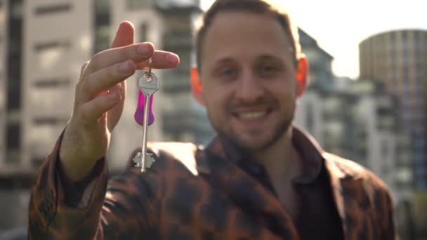 Ein Fröhlicher Junger Mann Zeigt Den Wohnungsschlüssel Konzept Des Immobilienerwerbs — Stockvideo