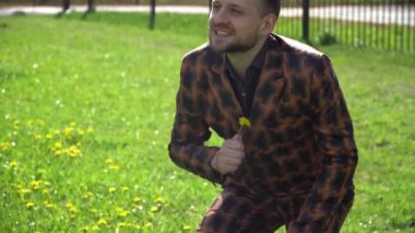 Genç bir adam iş merkezinin yakınındaki bir açıklıktan bir çiçek koparmış. Hayattan zevk alma ve mutlu bir gün..