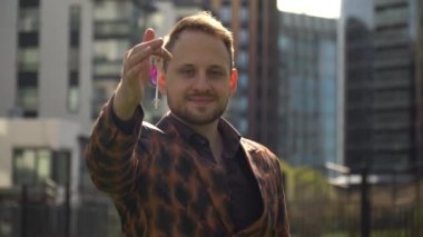 Genç bir emlakçı dairenin anahtarlarını müstakbel sahibine veriyor. konut satın alma kavramı.