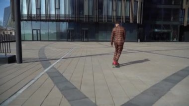 Genç adam kaykayın arka camında yuvarlanıyor. Güneşli bir günde uzun pano konsepti. Adam neredeyse düşüyordu..