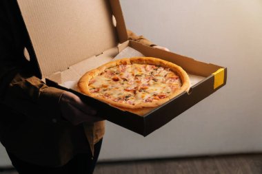 Nefis güzel Prosciutto pizzası ellerde. Teslimat yeri için fotoğraf ve yazı için boşluk.