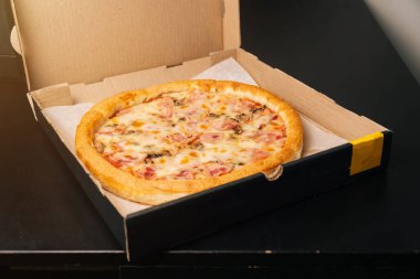 Nefis güzel Prosciutto pizzası ellerde. Teslimat yeri için fotoğraf ve yazı için boşluk.