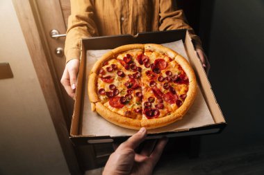 Yakın plan erkekler pepperonili pizza siparişini verir. Herhangi bir yere yemek teslimatı.