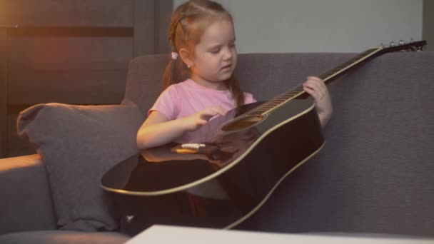 小さな美しい白人の子供のブロガーは カメラのアコースティックギターについて話し 加入者と彼女の意見を共有します ブログのコンセプト — ストック動画
