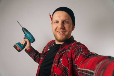 İnşaatçı, kafkas portresi yapan akıllı telefondan selfie çeken bir adamdır. Blog için tesisat fotoğrafçılığı kavramı