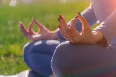 Eller namaste 'ye yakın olsun. Genç Kafkasyalı kız parkta yoga meditasyonu yapıyor. Huzur kavramı. Hayattaki denge ve uyum