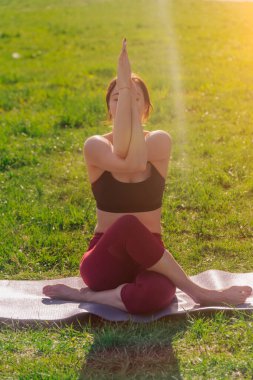 Dikey çerçevede, genç ve çekici bir kadının yoga yapması, kollarında Garudasan egzersizleri yapması, kartal duruşu, antrenman, spor kıyafetleri giymesi.,