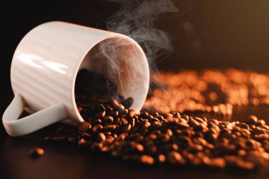 Kahve için beyaz, güzel bir fincan koyu bir arka planda, masanın üzerinde güzel bir bez üzerinde yatıyor..