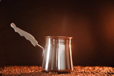 Koyu altın bir zemin üzerinde, kahve çekirdeğinin yanında taze demlenmiş kahve. Web sitesi için kahve menüsü tasarımı kavramı