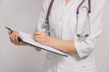 Kadın bir tıp doktoru ataçla panoya yakın çekim yapıyor. Hasta kontrolü, tıbbi hesaplama ve istatistik konsepti. Doktor hastayı muayene etmeye hazır..